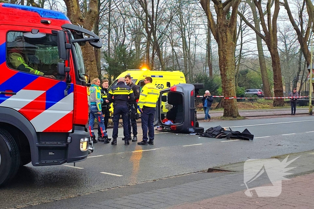 Auto belandt op zijn kant na botsing tegen boom