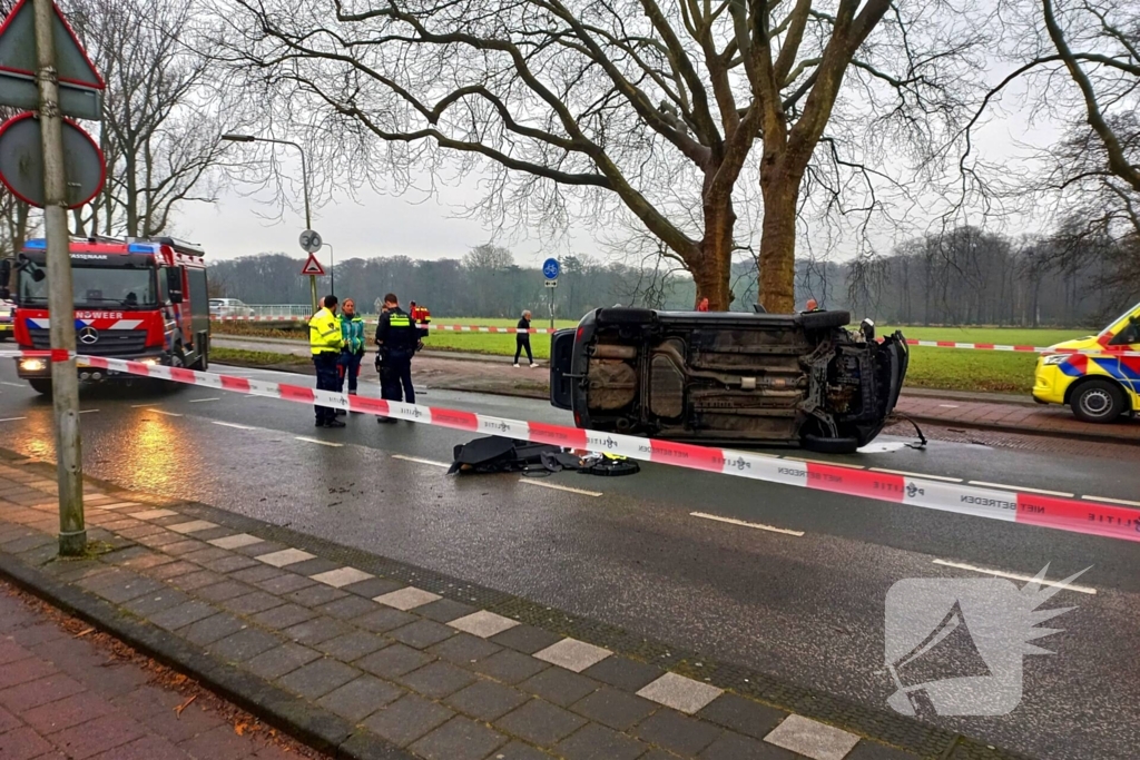 Auto belandt op zijn kant na botsing tegen boom
