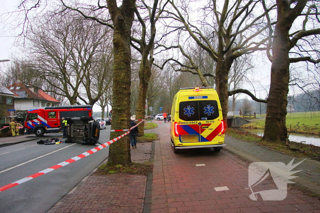 Auto belandt op zijn kant na botsing tegen boom