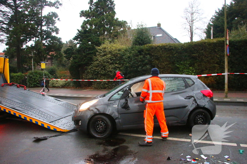 Auto belandt op zijn kant na botsing tegen boom
