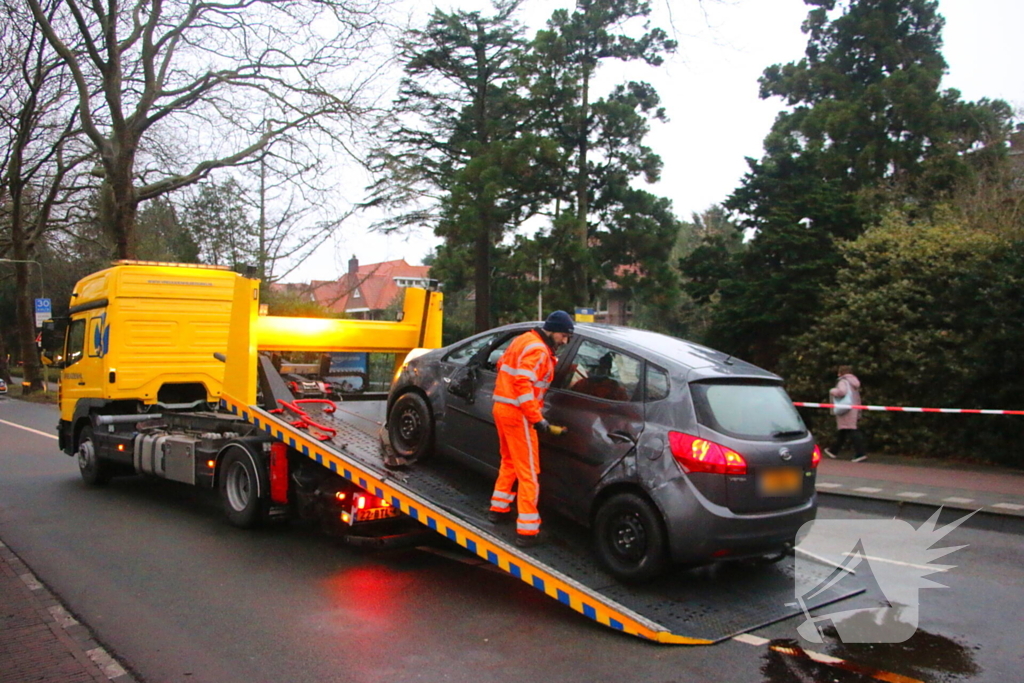 Auto belandt op zijn kant na botsing tegen boom