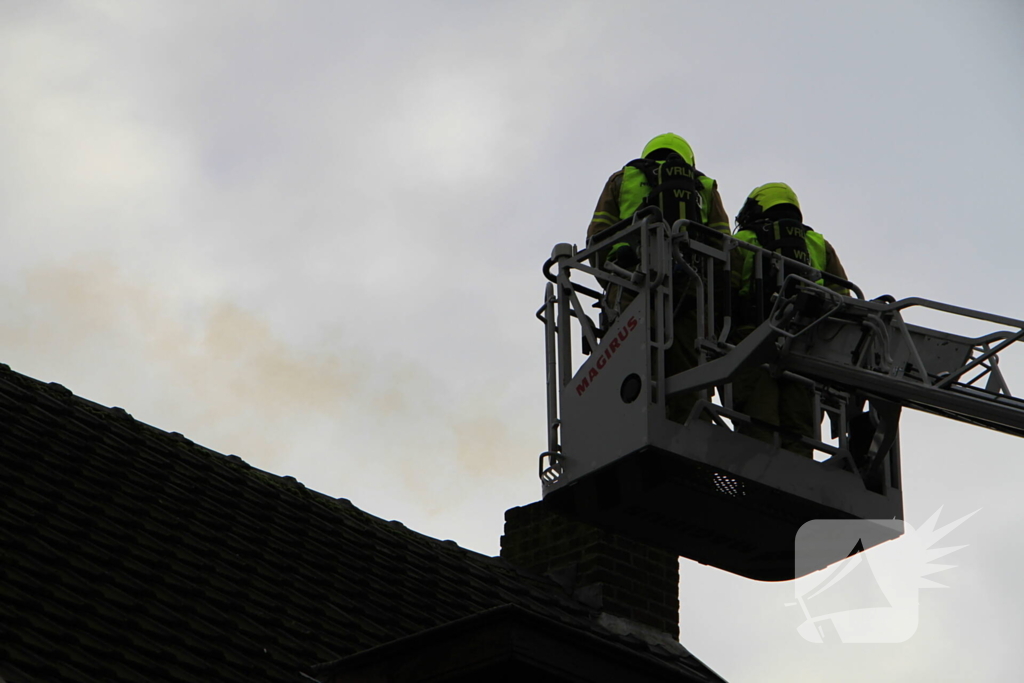 Brandweer controleer schoorsteen na brand