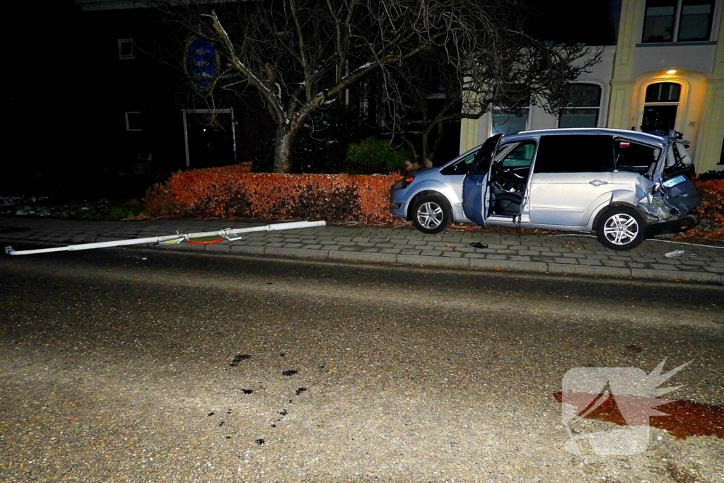 Taxi belandt in heg na botsing met vrachtwagen