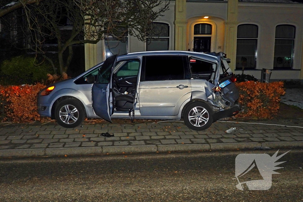 Taxi belandt in heg na botsing met vrachtwagen