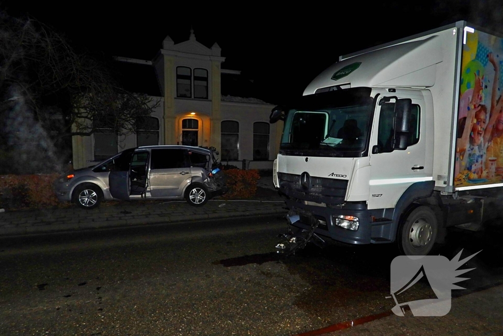 Taxi belandt in heg na botsing met vrachtwagen