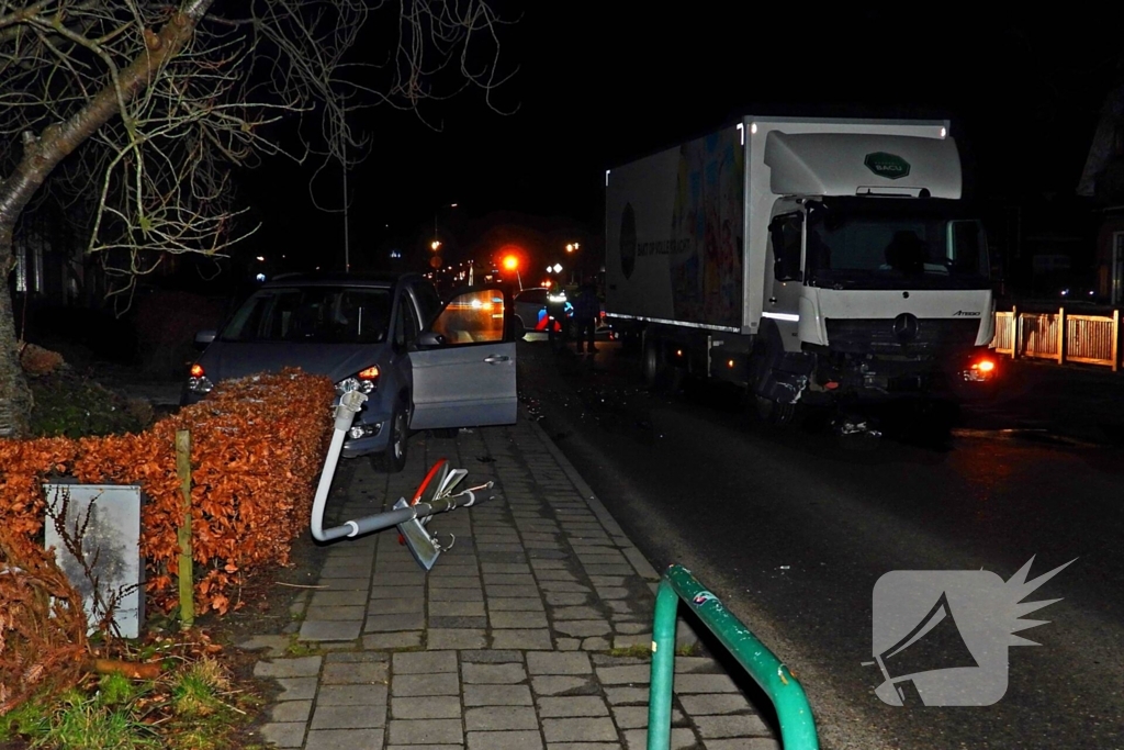 Taxi belandt in heg na botsing met vrachtwagen