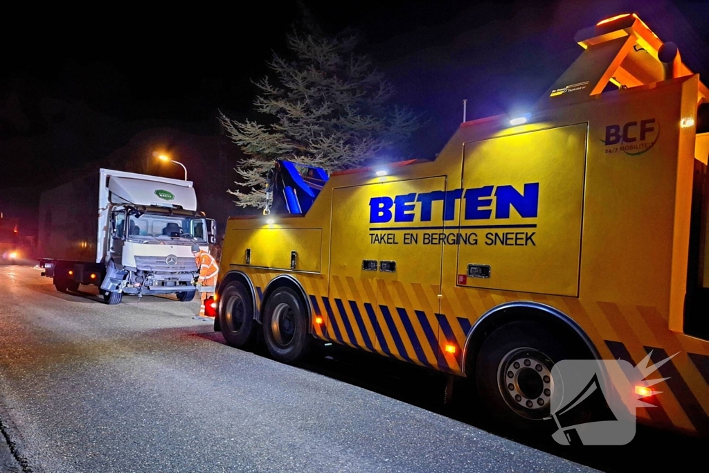 Taxi belandt in heg na botsing met vrachtwagen