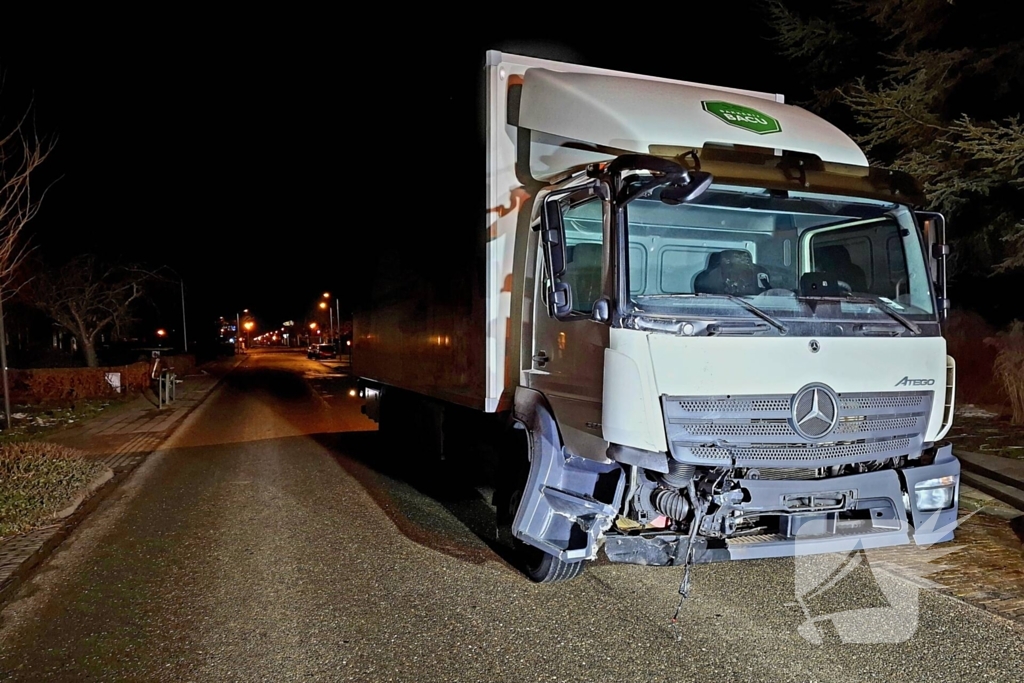Taxi belandt in heg na botsing met vrachtwagen