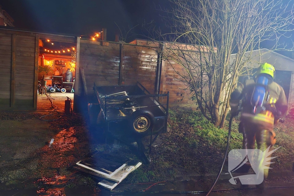 Vlammen slaan uit aanhanger, buurtbewoner start blussing