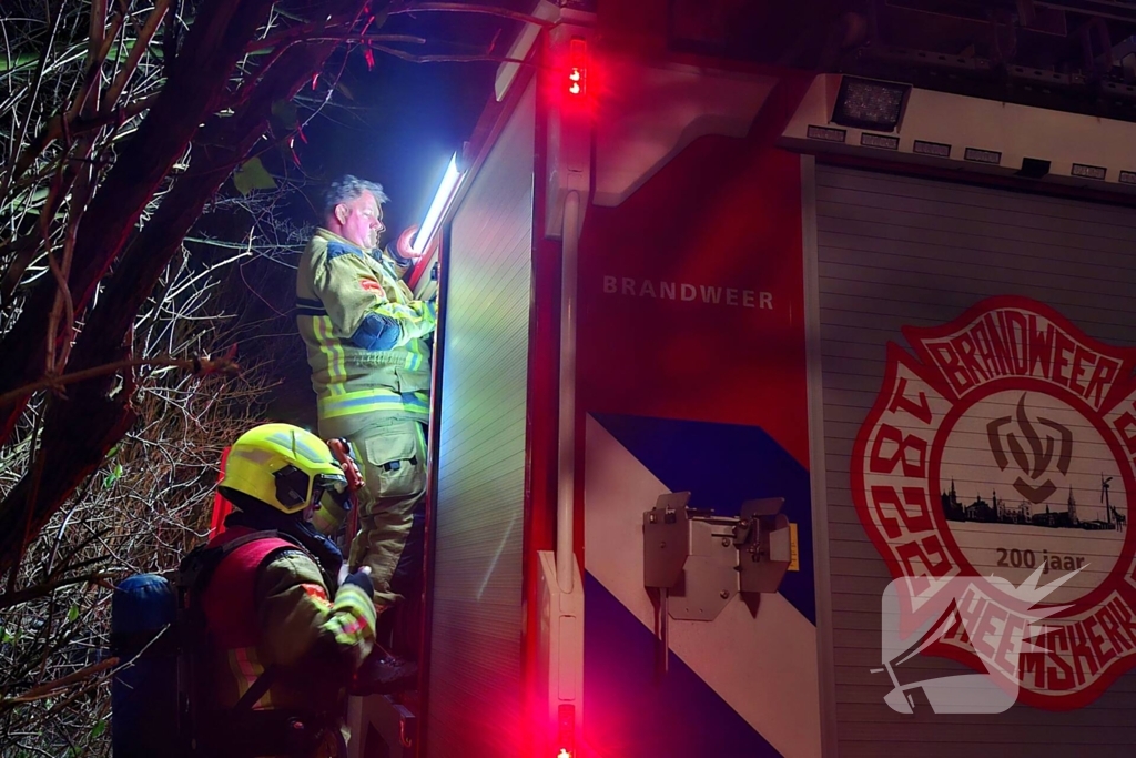 Vlammen slaan uit aanhanger, buurtbewoner start blussing