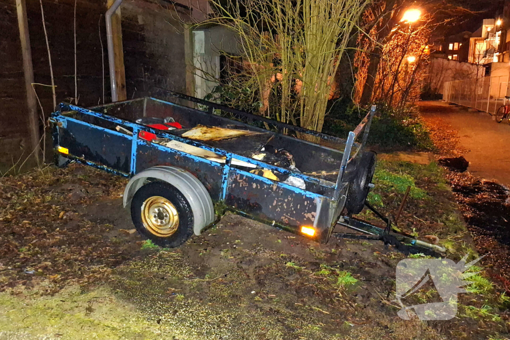Vlammen slaan uit aanhanger, buurtbewoner start blussing