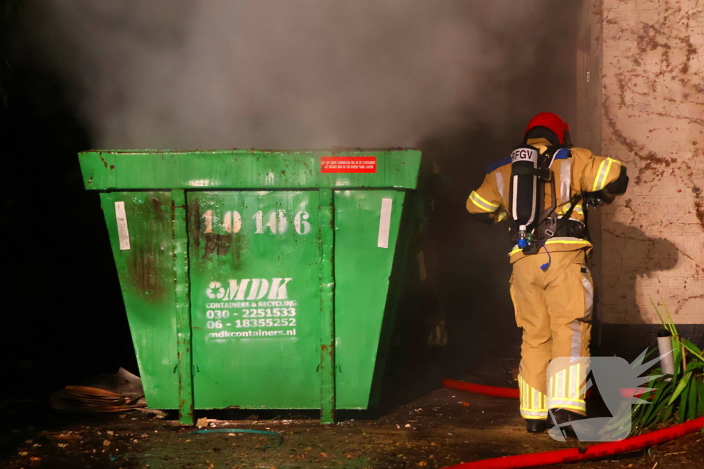 Bouwcontainer vat vlam naast woning met rietendak
