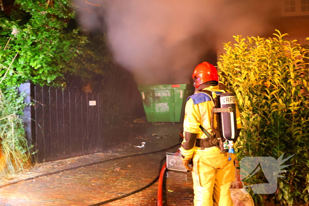 Bouwcontainer vat vlam naast woning met rietendak