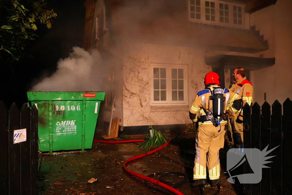 Bouwcontainer vat vlam naast woning met rietendak