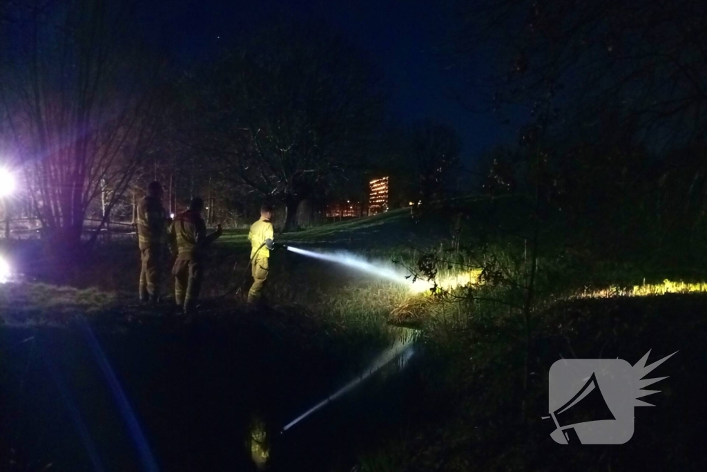 Brandweer blust brandend riet