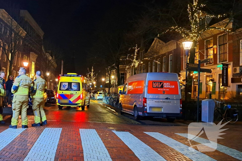 Persoon bekneld onder bestelbus