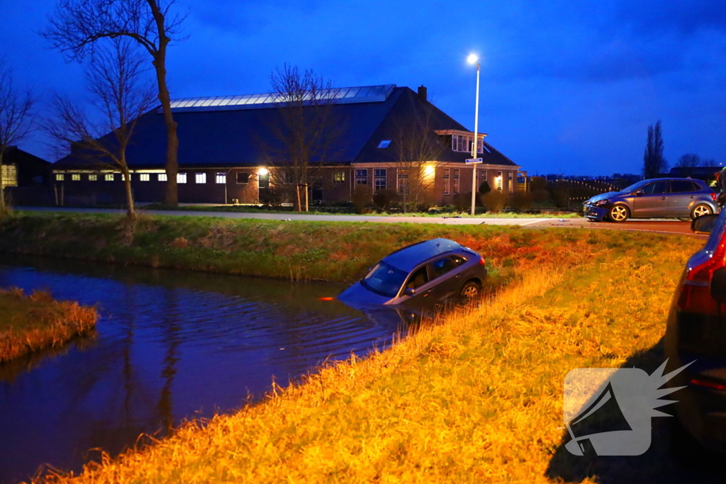 Auto te water na botsing op kruising