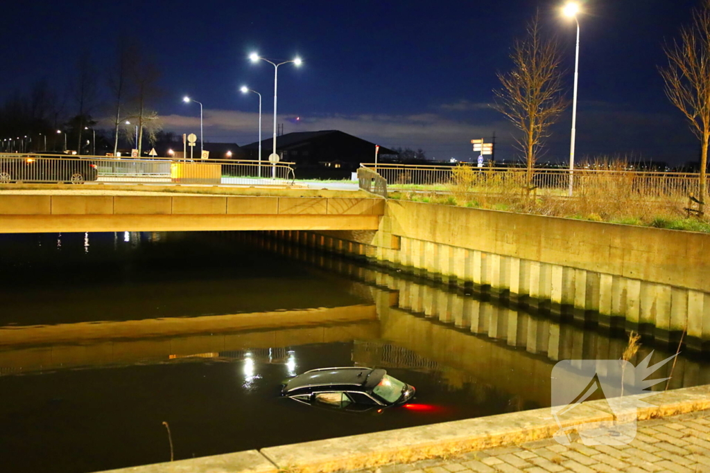 Auto rijdt rechtdoor op rotonde en belandt in water