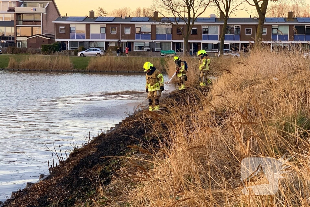 Winkelmedewerkers doen bluspoging bij rietbrand