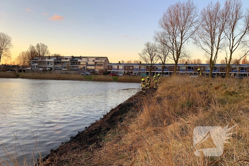 Winkelmedewerkers doen bluspoging bij rietbrand