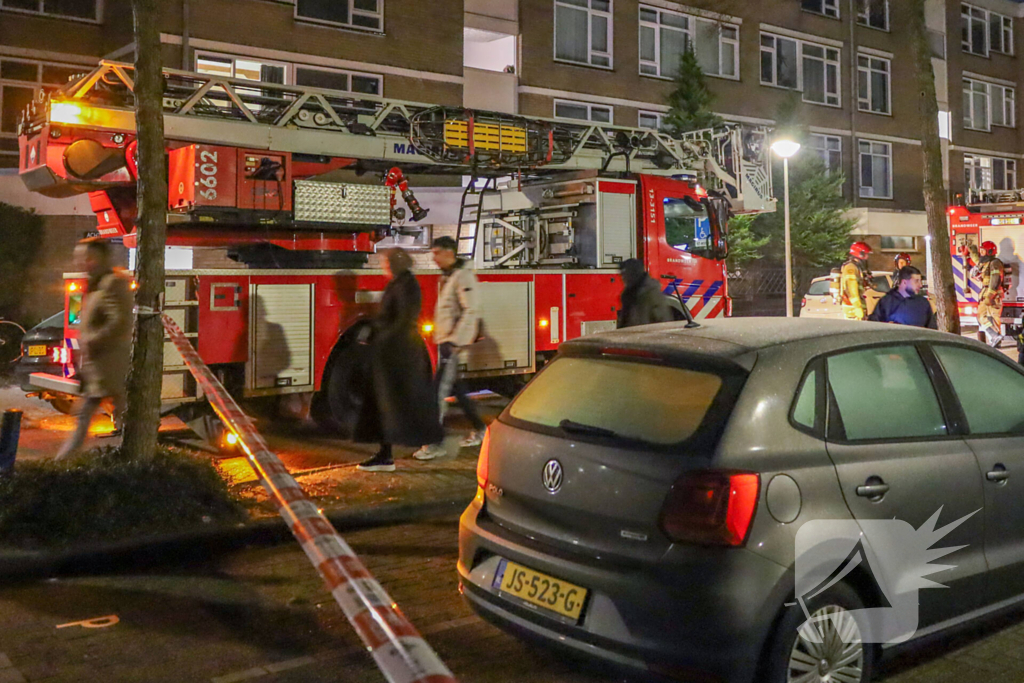 Explosie bij portiek van flatgebouw, brandweer blust vuurhaard