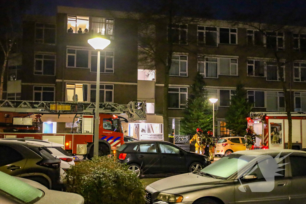 Explosie bij portiek van flatgebouw, brandweer blust vuurhaard