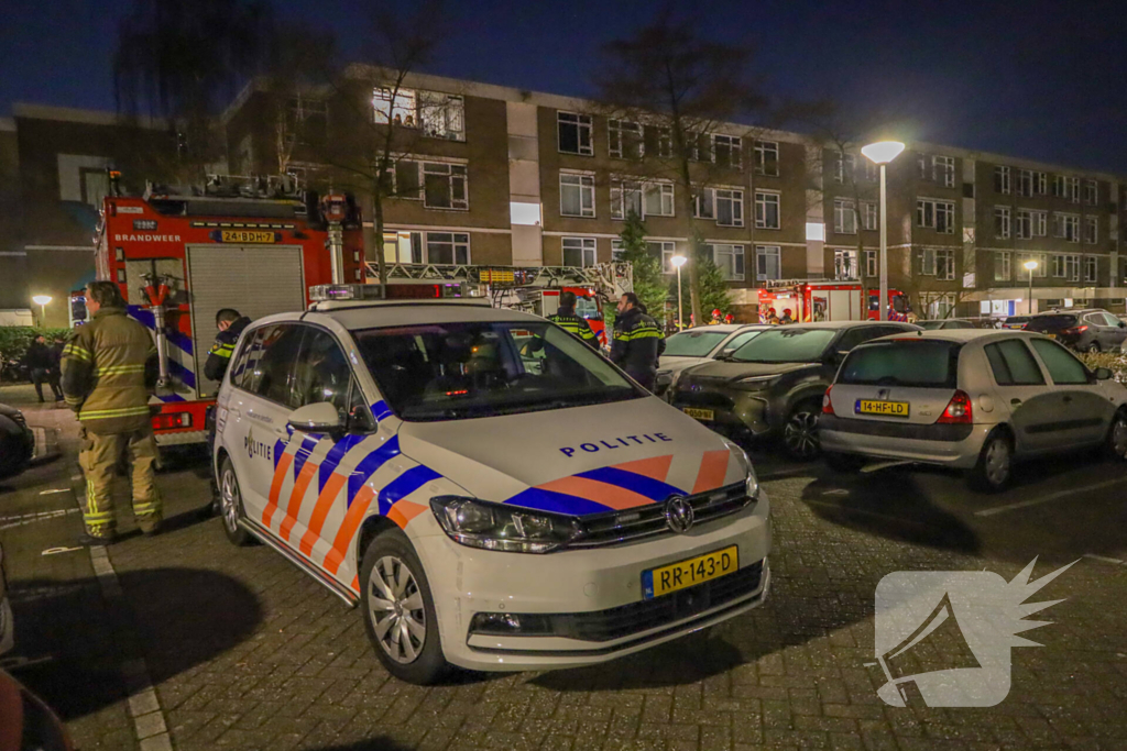 Explosie bij portiek van flatgebouw, brandweer blust vuurhaard