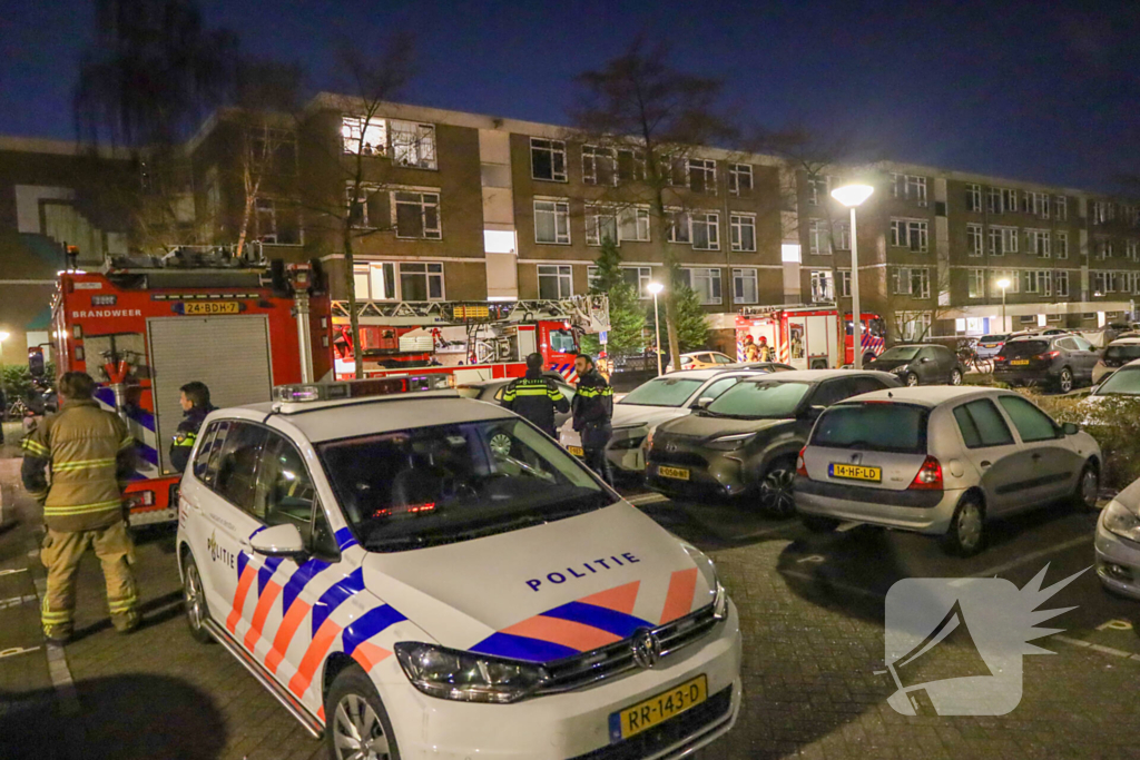 Explosie bij portiek van flatgebouw, brandweer blust vuurhaard