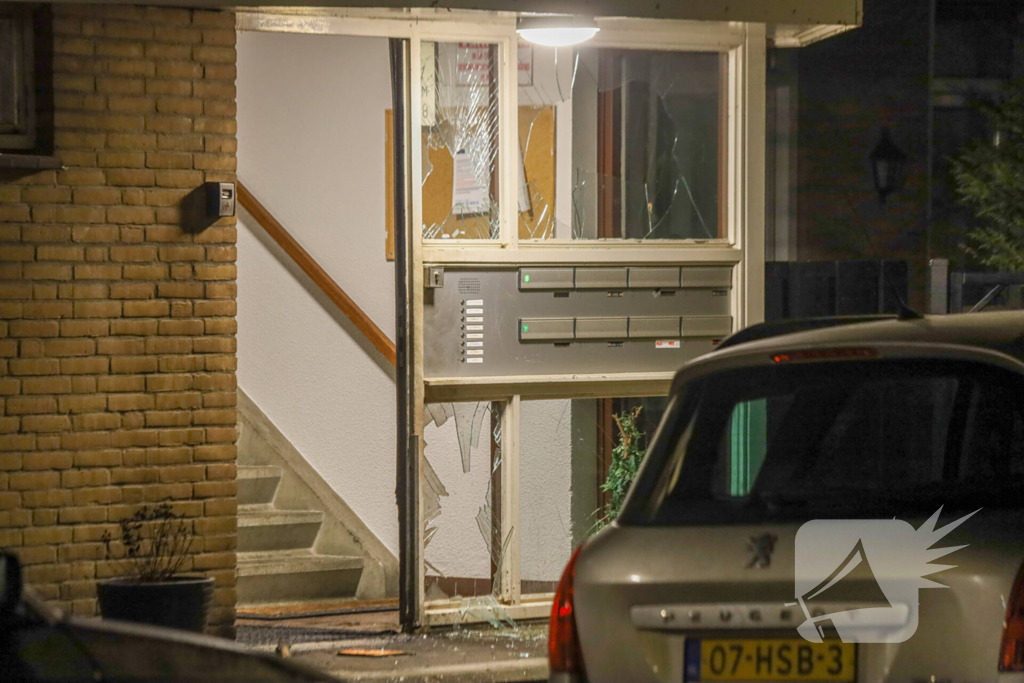 Explosie bij portiek van flatgebouw, brandweer blust vuurhaard