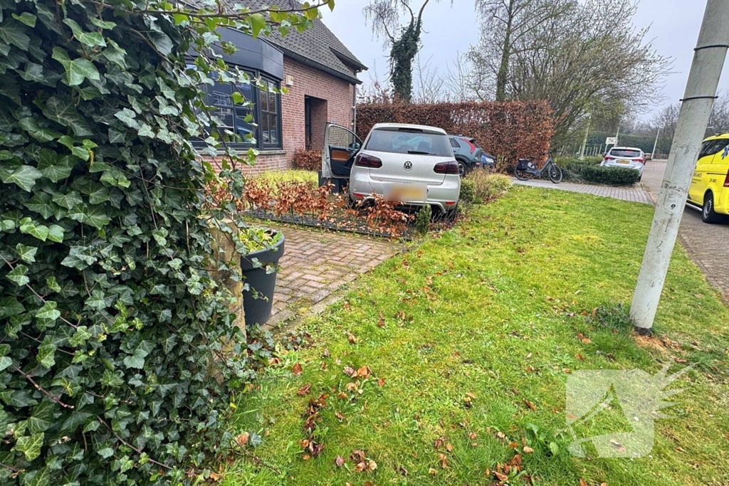 Automobilist rijdt voortuin in