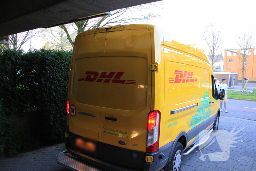 DHL-bezorger rijdt zichzelf vast onder appartementen