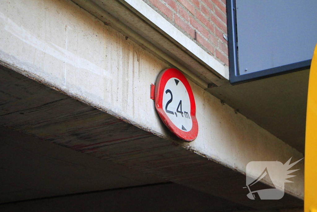 DHL-bezorger rijdt zichzelf vast onder appartementen