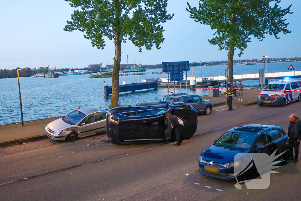 Auto botst op drie geparkeerde auto's en belandt op zijkant