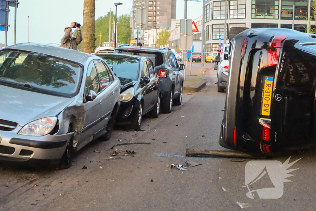 Auto botst op drie geparkeerde auto's en belandt op zijkant