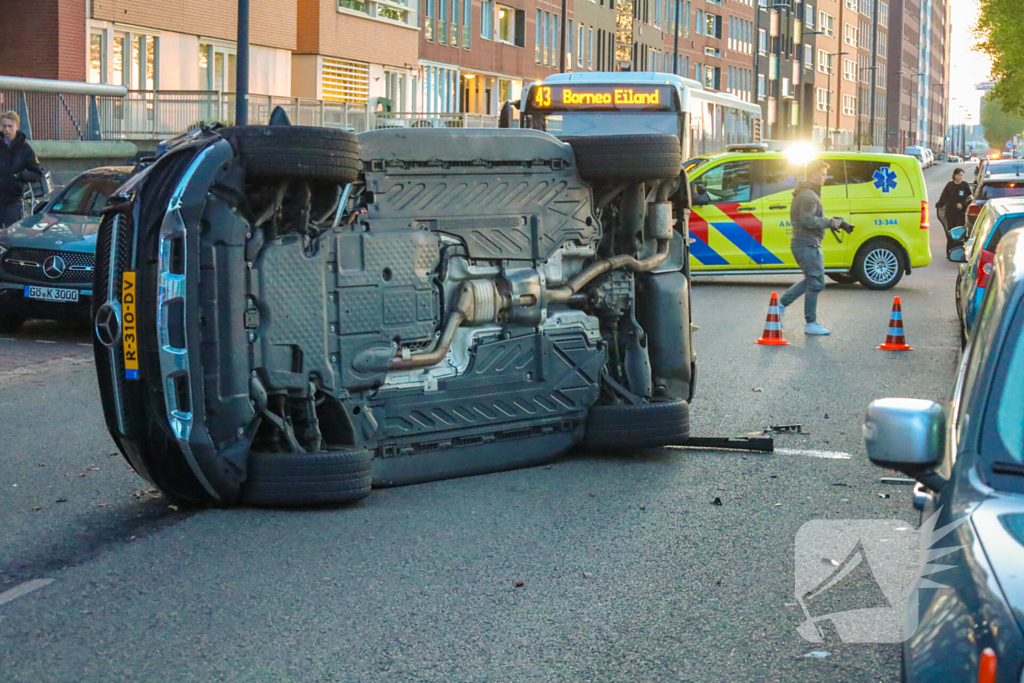 Auto botst op drie geparkeerde auto's en belandt op zijkant