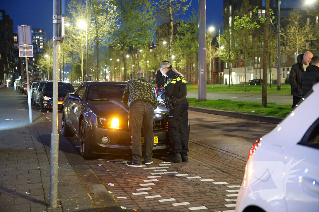 Maaltijdbezorger klapt tegen auto en komt ten val