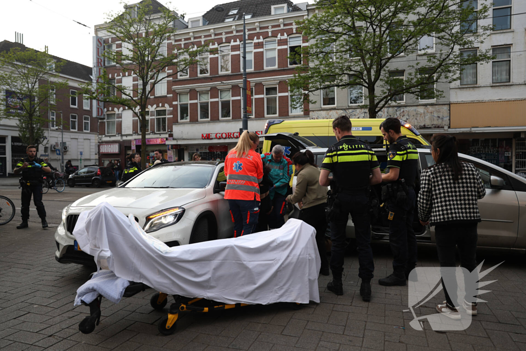 Persoon bekneld tussen twee voertuigen