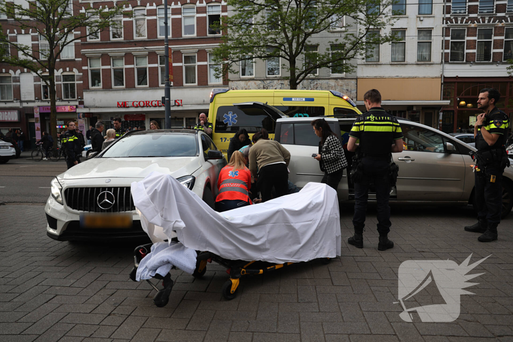 Persoon bekneld tussen twee voertuigen