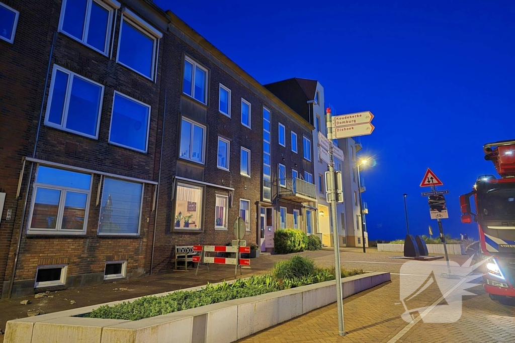 Brokstukken op stoep van gevel