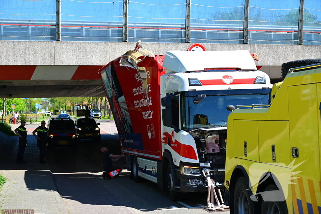 Veel schade nadat vrachtwagen klem raakt onder viaduct