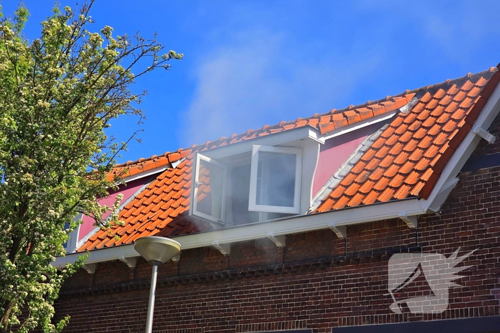 Brandweer slaat raam in wegens brand