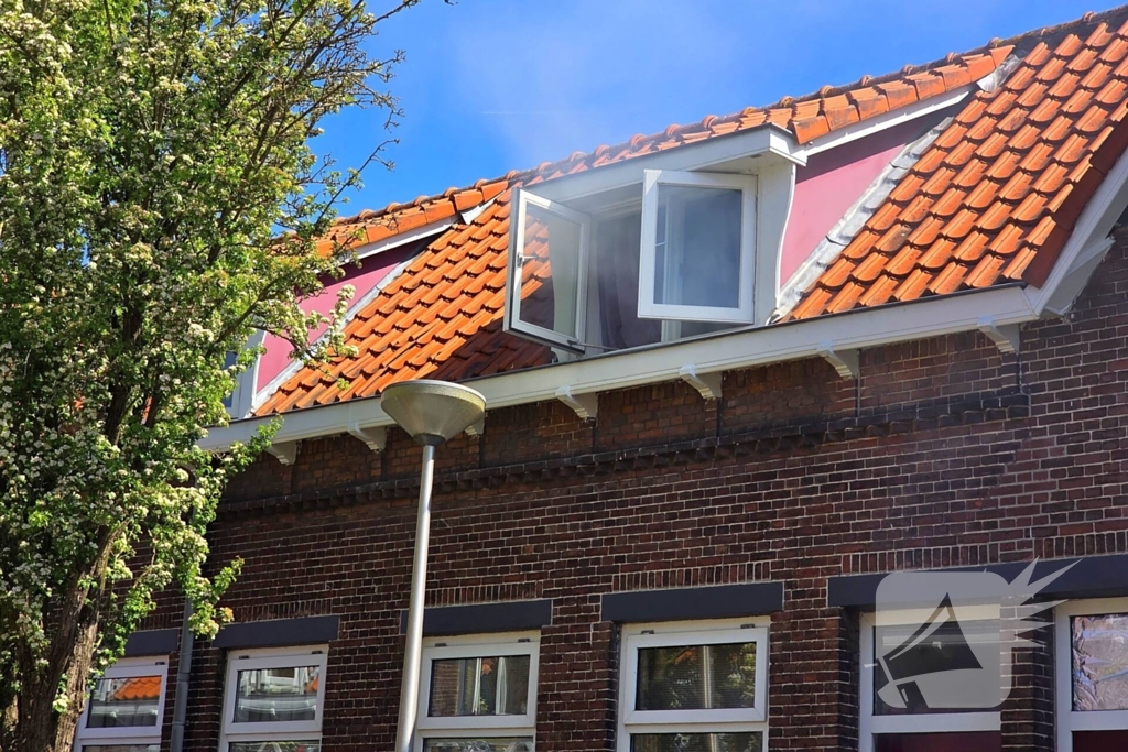 Brandweer slaat raam in wegens brand