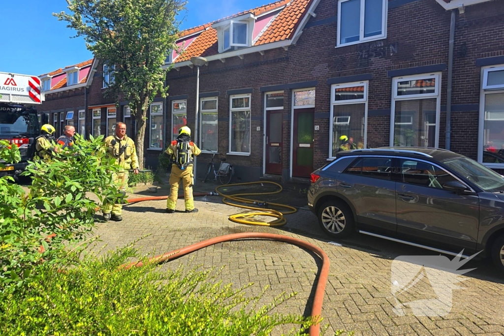 Brandweer slaat raam in wegens brand