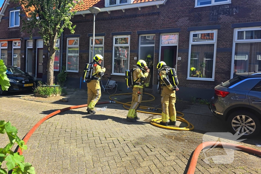 Brandweer slaat raam in wegens brand