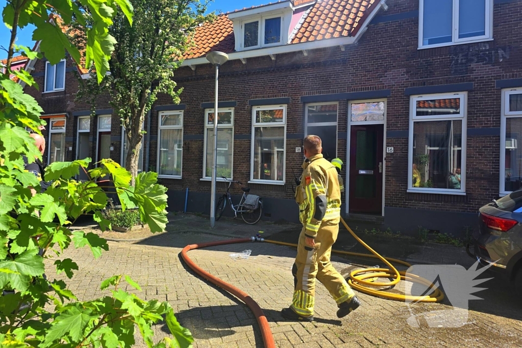 Brandweer slaat raam in wegens brand