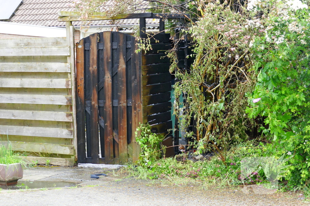 Schade aan poort en schutting door brand