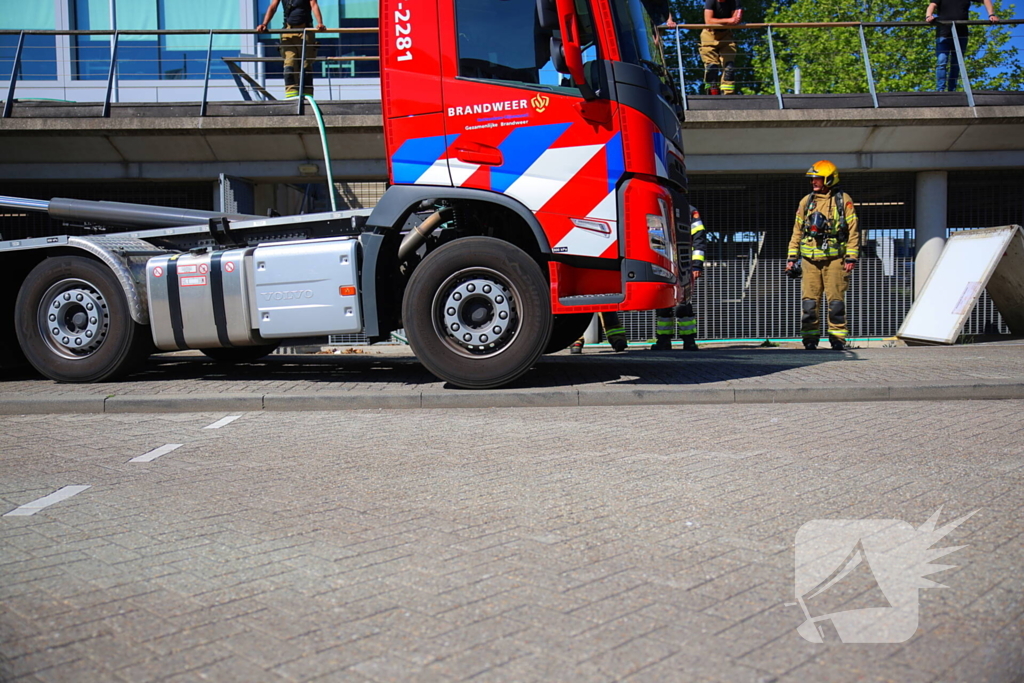 Vlammen slaan uit grote afvalcontainer