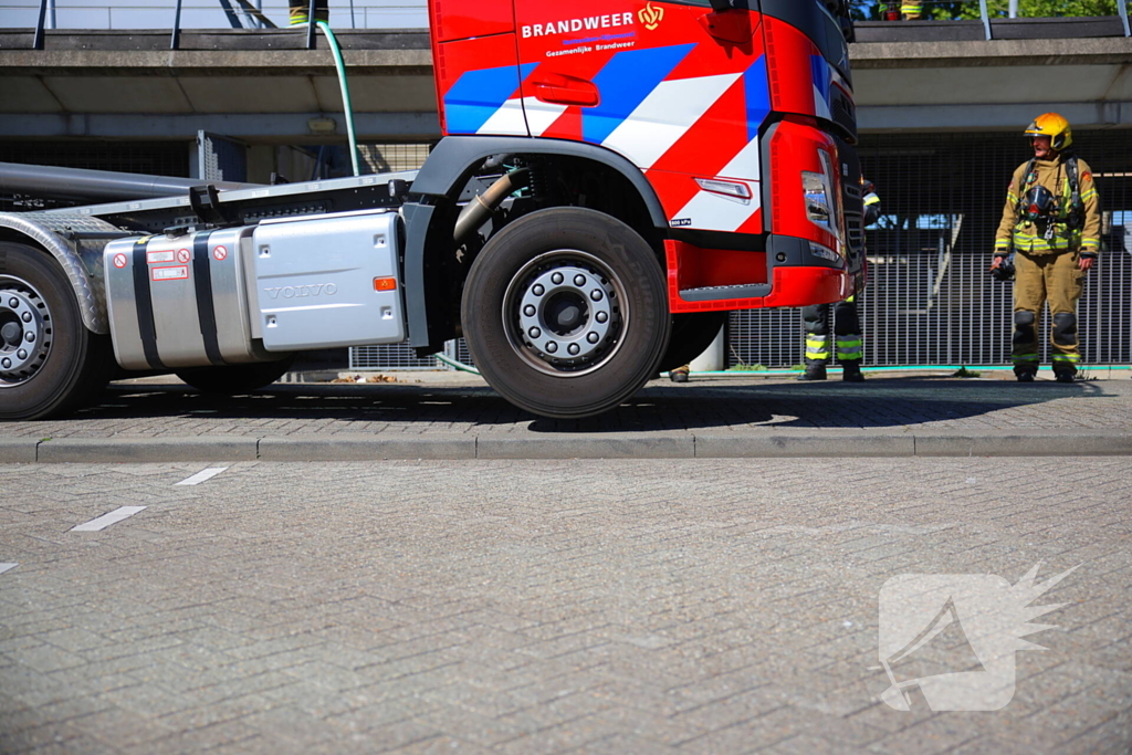 Vlammen slaan uit grote afvalcontainer