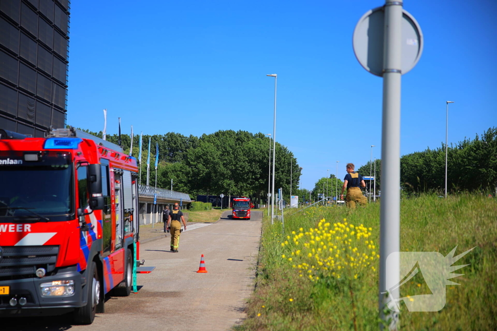 Vlammen slaan uit grote afvalcontainer