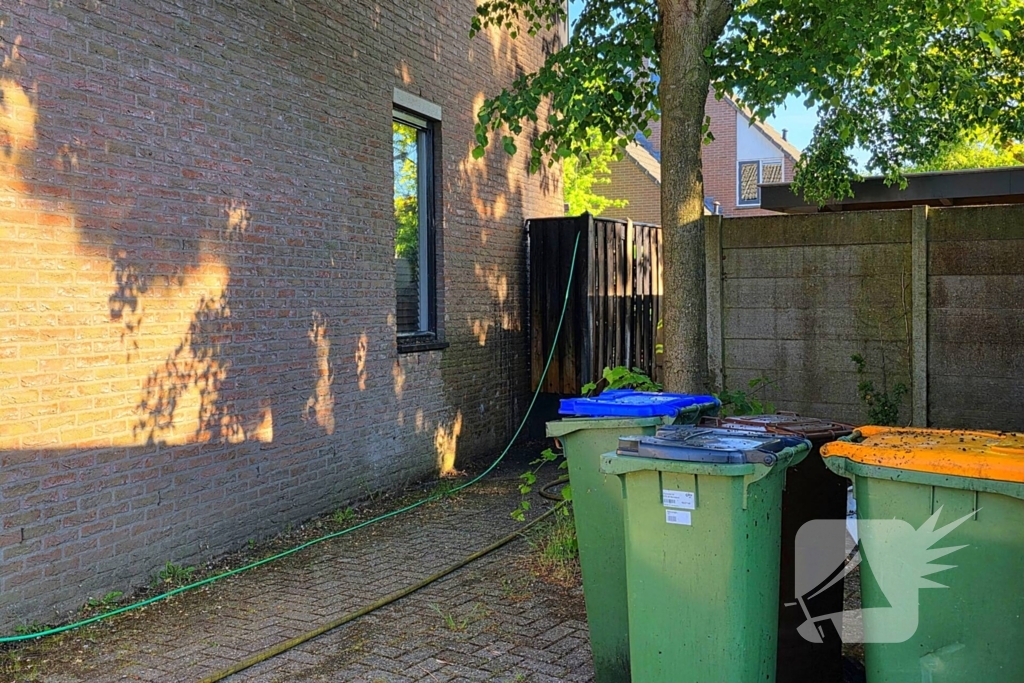 Schutting naast woning in brand